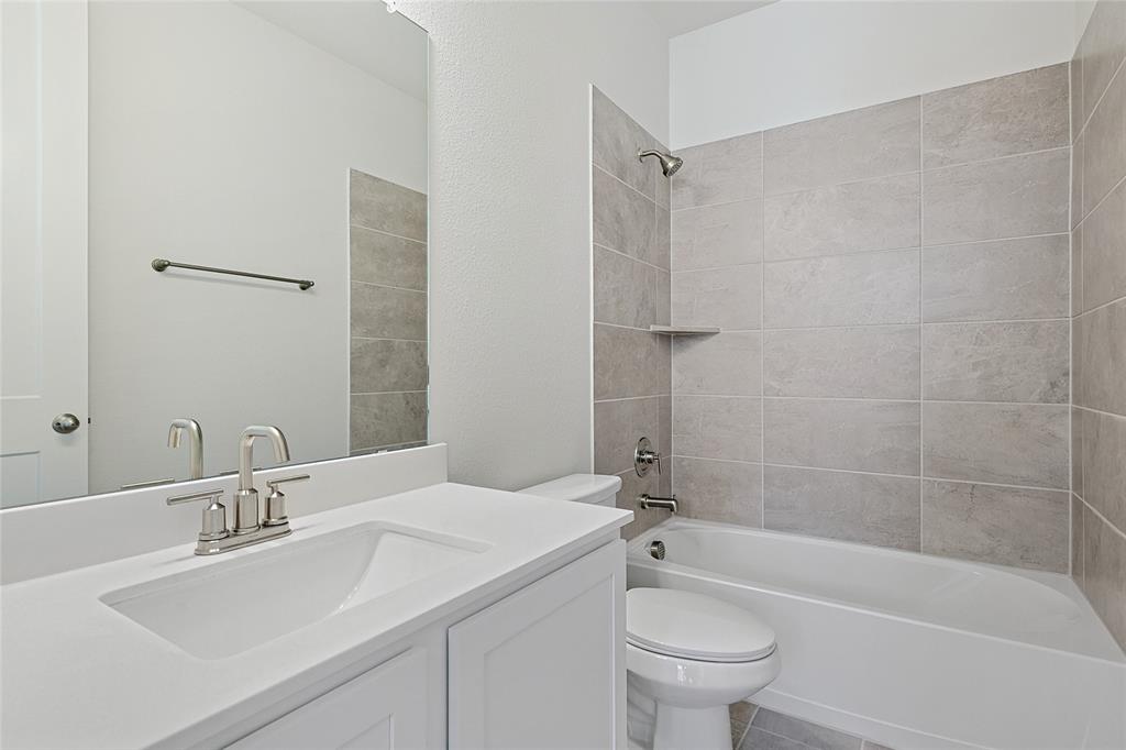 809 Concan Drive Plano, TX 75075 - Photo 39 of 40 Full bathroom featuring tiled shower / bath combo, vanity, and toilet