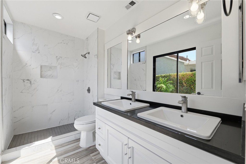9841 Golden Arrow Lane Rancho Cucamonga, CA 91701 - Photo 20 of 53 a bathroom with a sink a toilet and a large mirror