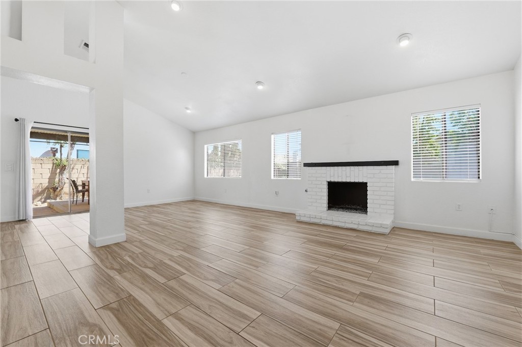 9841 Golden Arrow Lane Rancho Cucamonga, CA 91701 - Photo 5 of 53 an empty room with wooden floor and fireplace