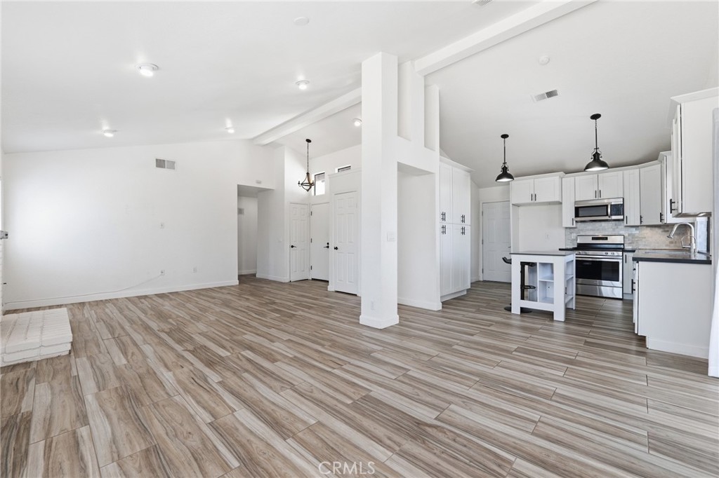 9841 Golden Arrow Lane Rancho Cucamonga, CA 91701 - Photo 7 of 53 a kitchen with stainless steel appliances a refrigerator and wooden floor