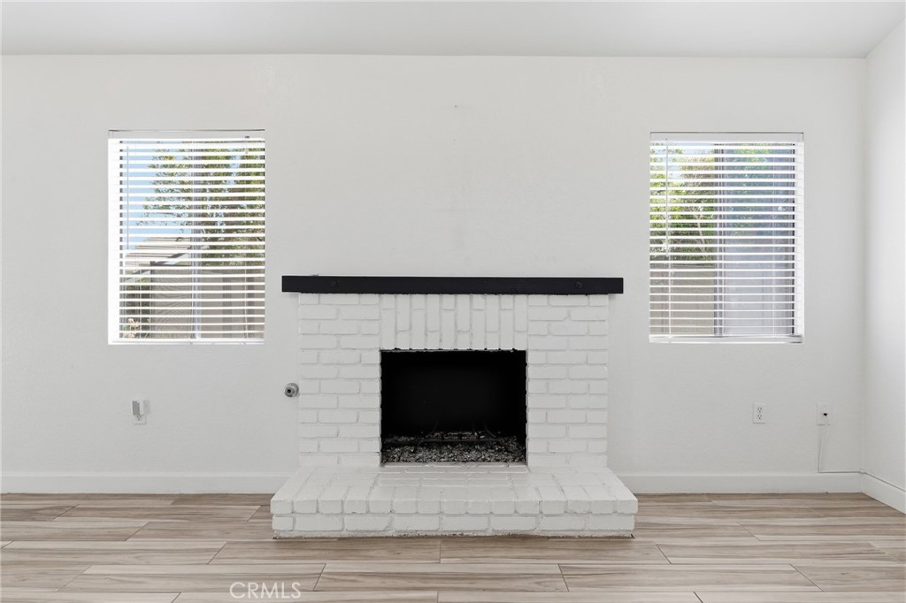 9841 Golden Arrow Lane Rancho Cucamonga, CA 91701 - Photo 10 of 53 a living room with a fireplace and windows