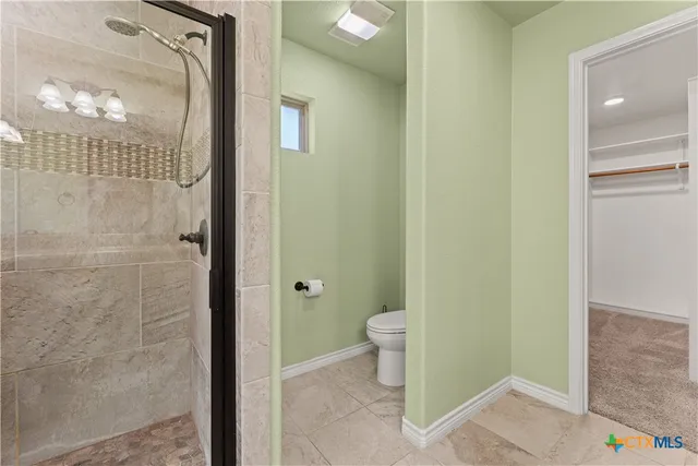 a bathroom with a granite countertop shower and a toilet
