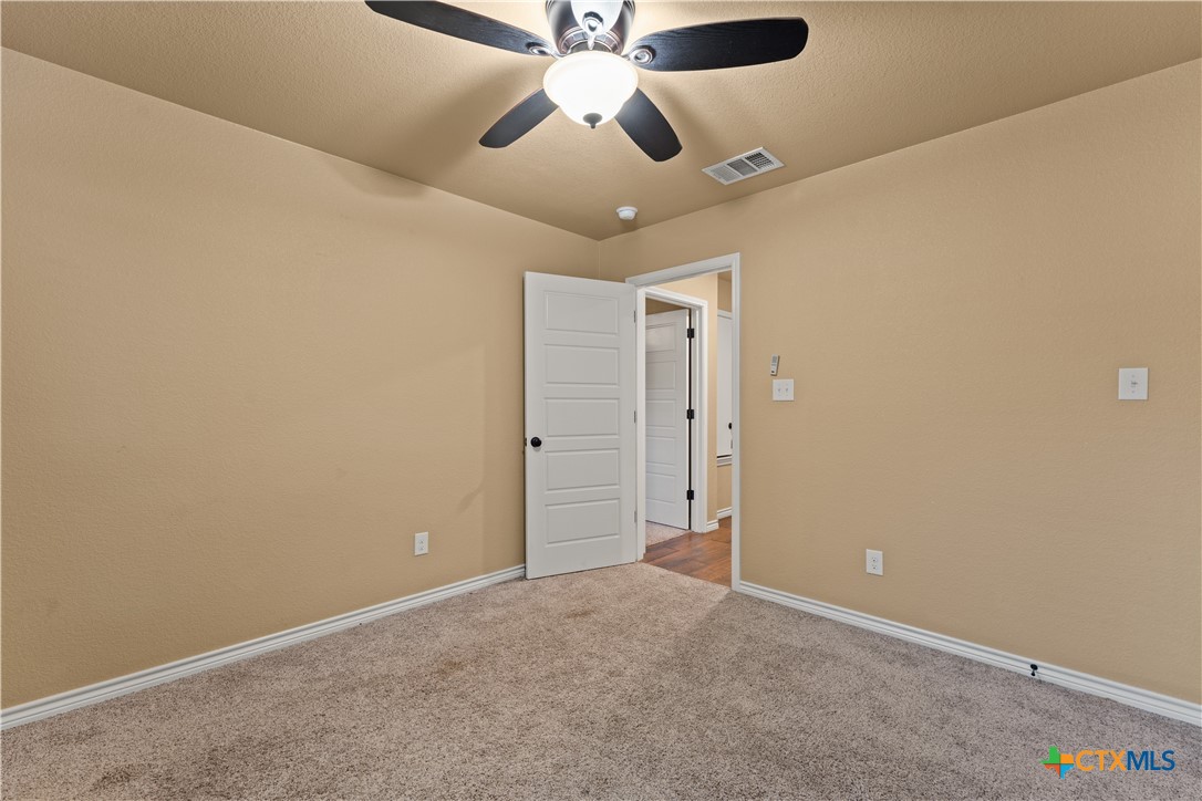 250 Old Waco Road Gatesville, TX 76528 - Photo 18 of 23 an empty room with a ceiling fan and a fan