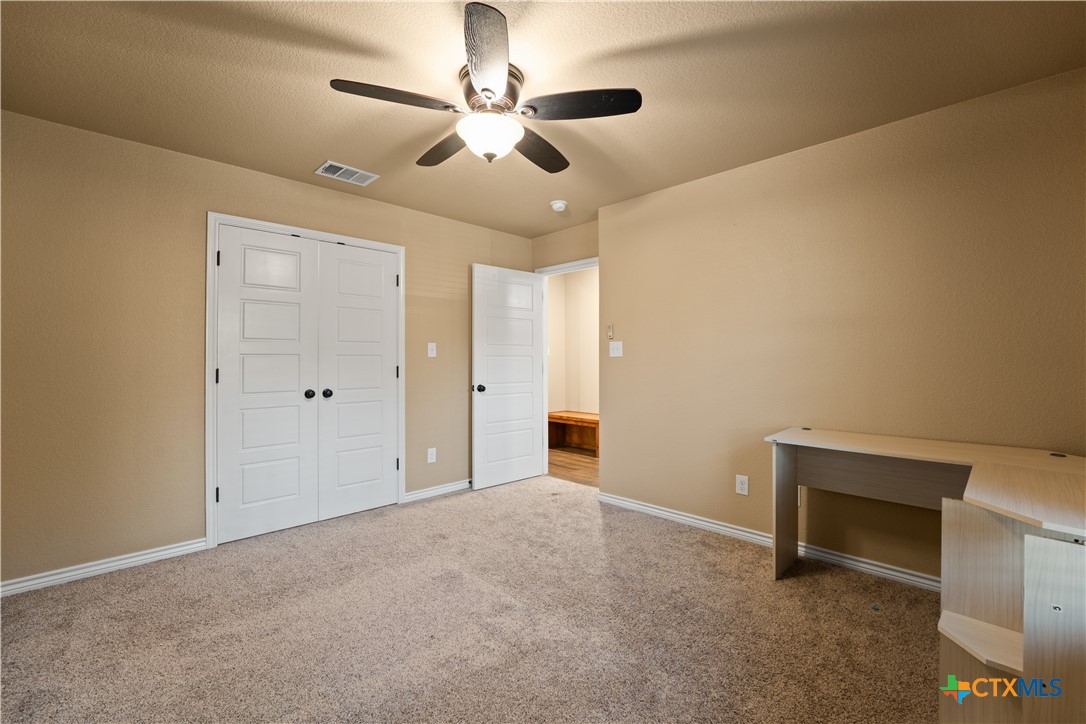 250 Old Waco Road Gatesville, TX 76528 - Photo 19 of 23 an empty room with chandelier fan and windows