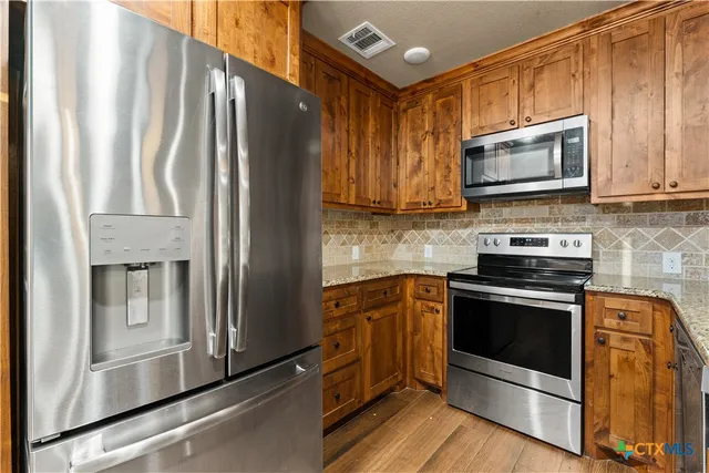 a kitchen with stainless steel appliances a stove microwave and sink