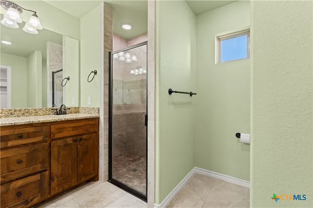 a bathroom with a shower sink and mirror
