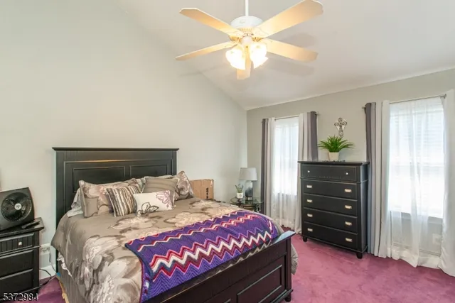 a bedroom with a bed a chandelier and a dresser