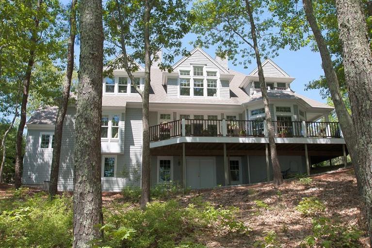 7 Harbor Ridge Road Mashpee, MA 02649 - Photo 2 of 26 a view of a white house with large windows and a tree