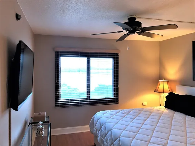 a bedroom with a bed and a flat tv screen on dresser