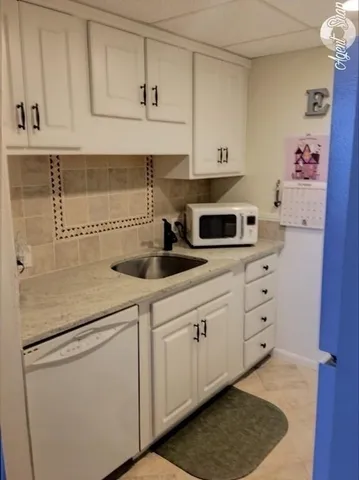 a kitchen with stainless steel appliances white cabinets and white appliances