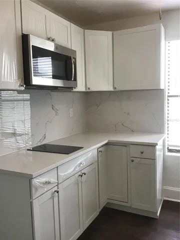 a kitchen with stainless steel appliances granite countertop white cabinets a sink and dishwasher