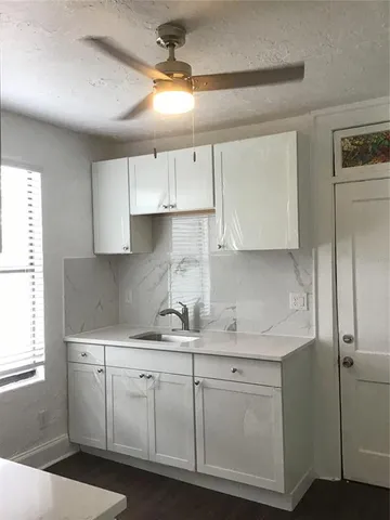 a kitchen with a sink dishwasher and white cabinets