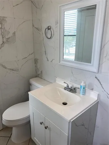 a bathroom with a sink a toilet and a window