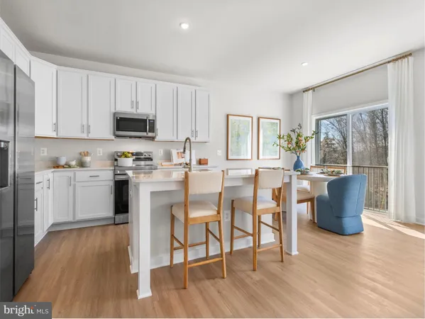 a kitchen with a dining table chairs and refrigerator