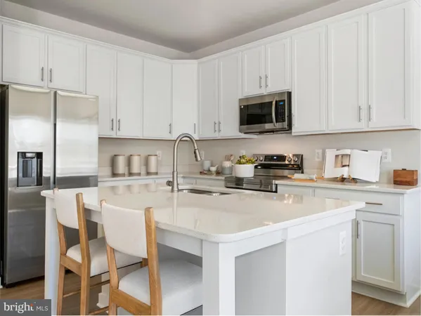 a kitchen with stainless steel appliances granite countertop a stove a sink a microwave and white cabinets