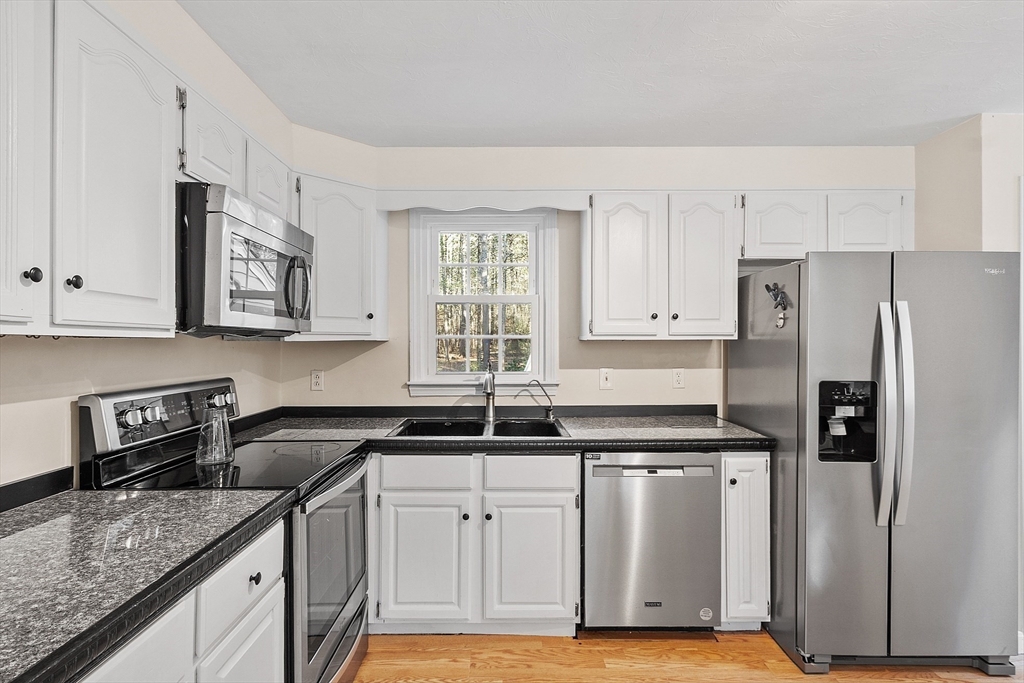 4.5 Old Battery Road Townsend, MA 01474 - Photo 2 of 42 a kitchen with white cabinets and a sink