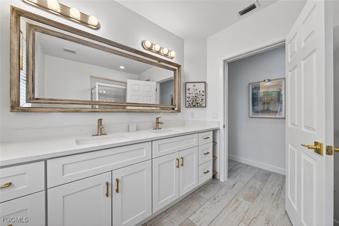 13570 Harbour Ridge Drive Fort Myers, FL 33908 - Photo 35 of 50 a bathroom with a double vanity sink and a mirror