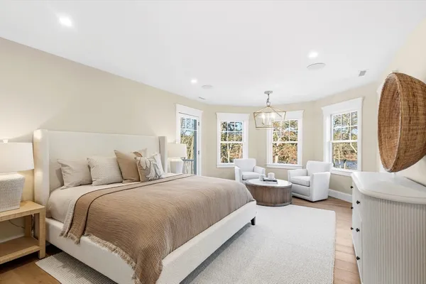 a bedroom with a large bed and windows