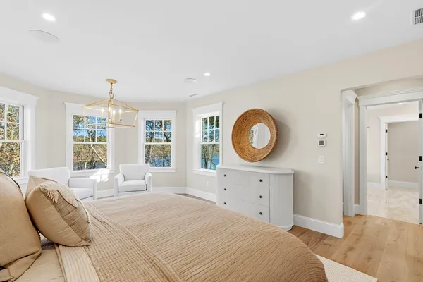 a spacious bedroom with a large bed and a chandelier