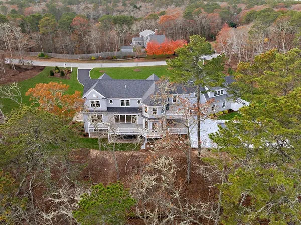 an aerial view of a house with a garden and lake view