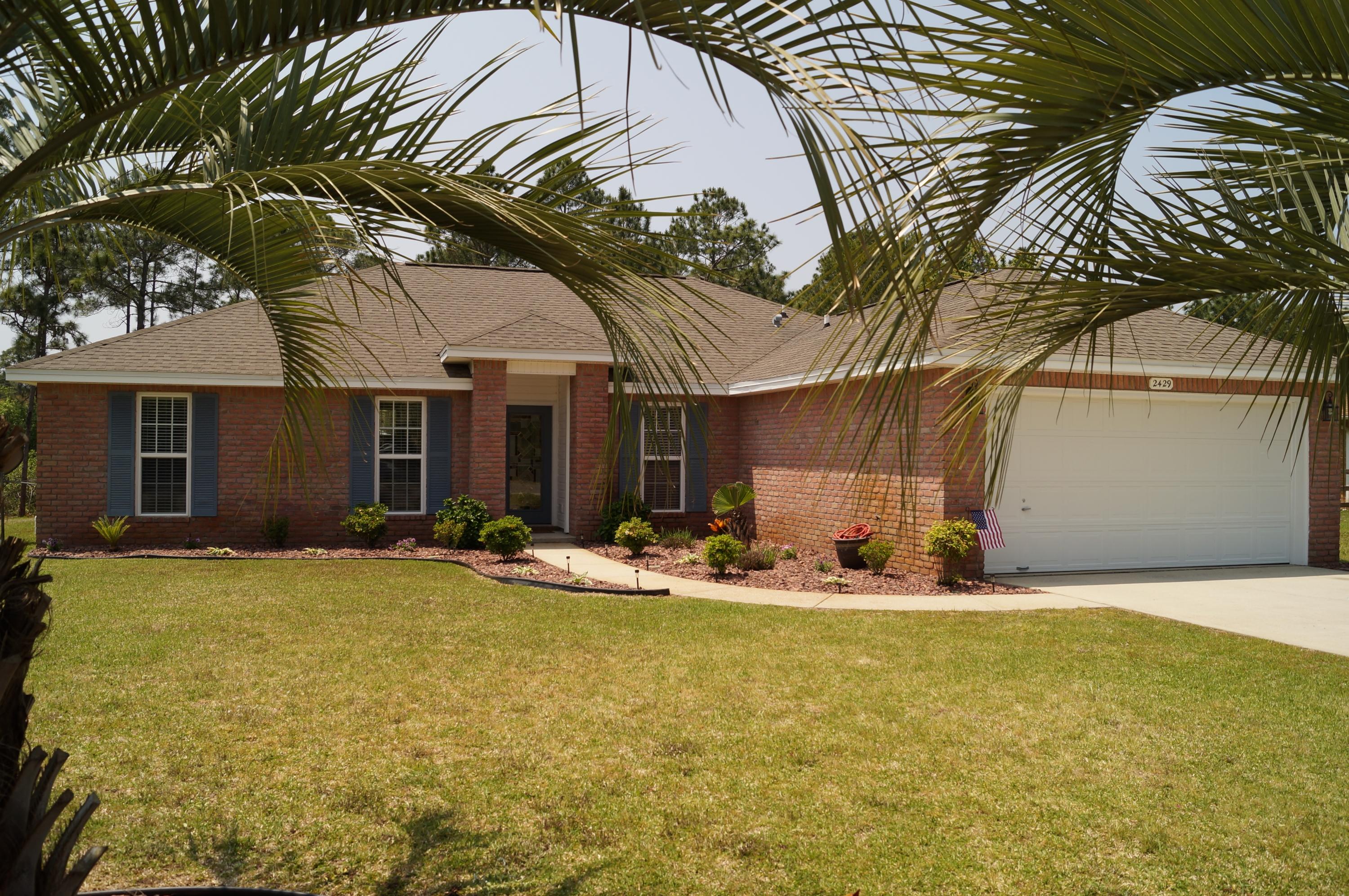 2429 Valley Road Navarre, FL 32566 - Photo 2 of 31 a backyard of a house with table and chairs