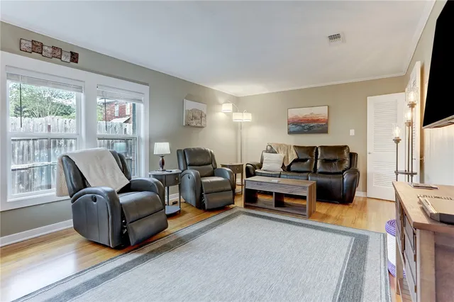 a living room with furniture a flat screen tv and a large window