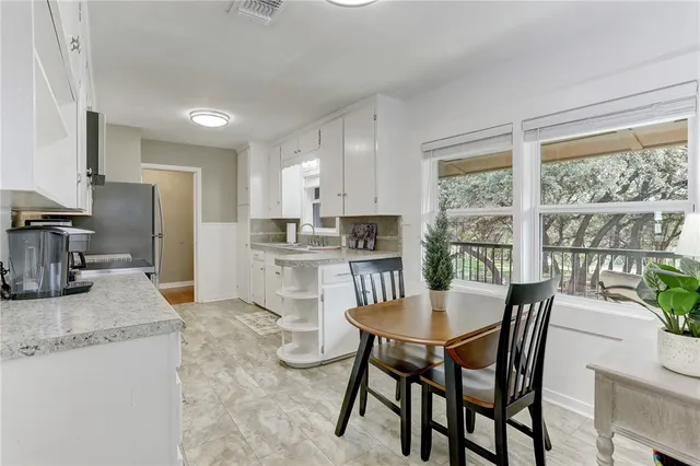 a kitchen with stainless steel appliances granite countertop a sink dishwasher stove and white cabinets with wooden floor