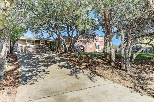a view of a house with large tree in front of it