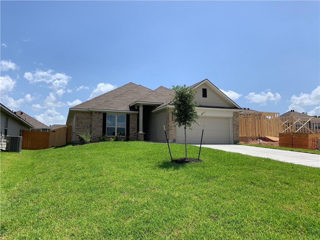 139 Bates Court Huntsville, TX 77320 - Photo 3 of 21 a yellow house with a yard and a large tree