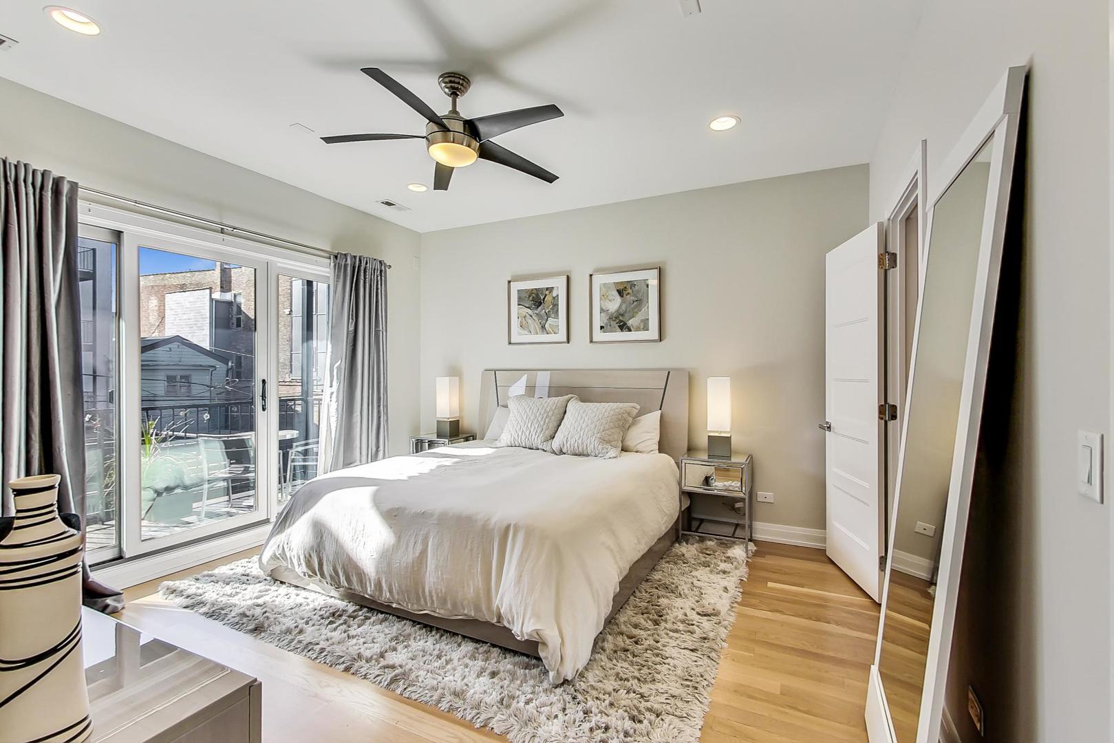 1525 West Fry Street, Unit 2 Chicago, IL 60642 - Photo 11 of 33 a bedroom with a large bed and a chandelier