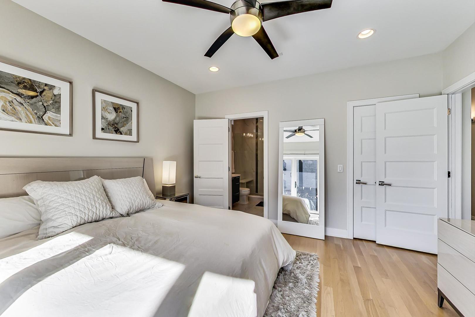 1525 West Fry Street, Unit 2 Chicago, IL 60642 - Photo 12 of 33 a bedroom with a large bed and a chandelier