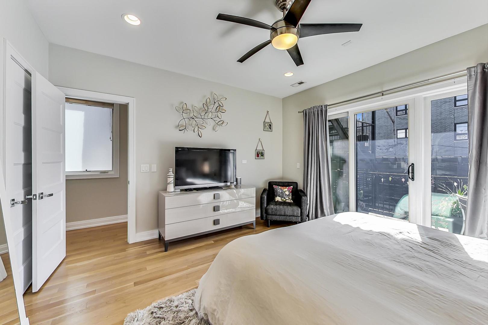 1525 West Fry Street, Unit 2 Chicago, IL 60642 - Photo 13 of 33 a bedroom with a bed and a flat screen tv