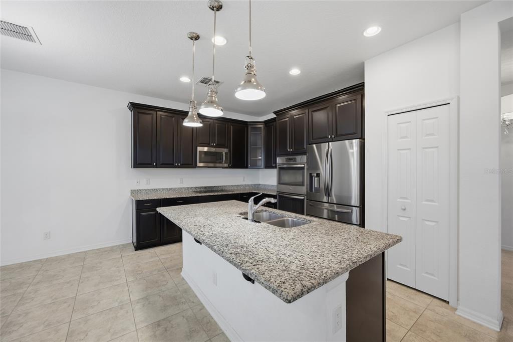 19656 Long Lake Ranch Boulevard Lutz, FL 33558 - Photo 8 of 44 a kitchen with stainless steel appliances granite countertop a sink refrigerator and microwave