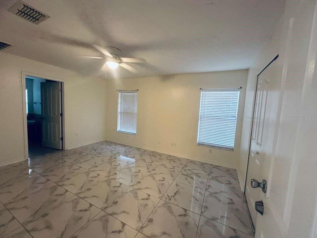 8344 Dorsey Street Spring Hill, FL 34608 - Photo 2 of 10 a view of an empty room with window and chandelier fan