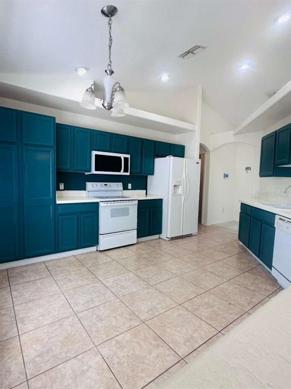 8344 Dorsey Street Spring Hill, FL 34608 - Photo 6 of 10 a kitchen with stainless steel appliances granite countertop a refrigerator oven a sink dishwasher and a microwave oven on the blue kitchen countertops