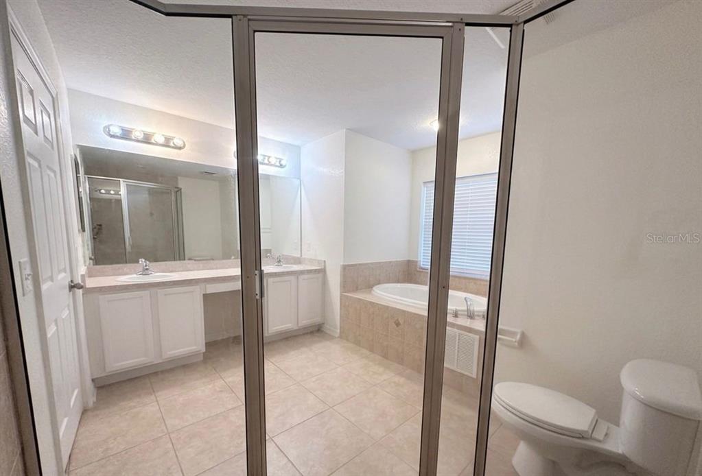 8344 Dorsey Street Spring Hill, FL 34608 - Photo 8 of 10 a bathroom with a granite countertop sink mirror vanity and toilet