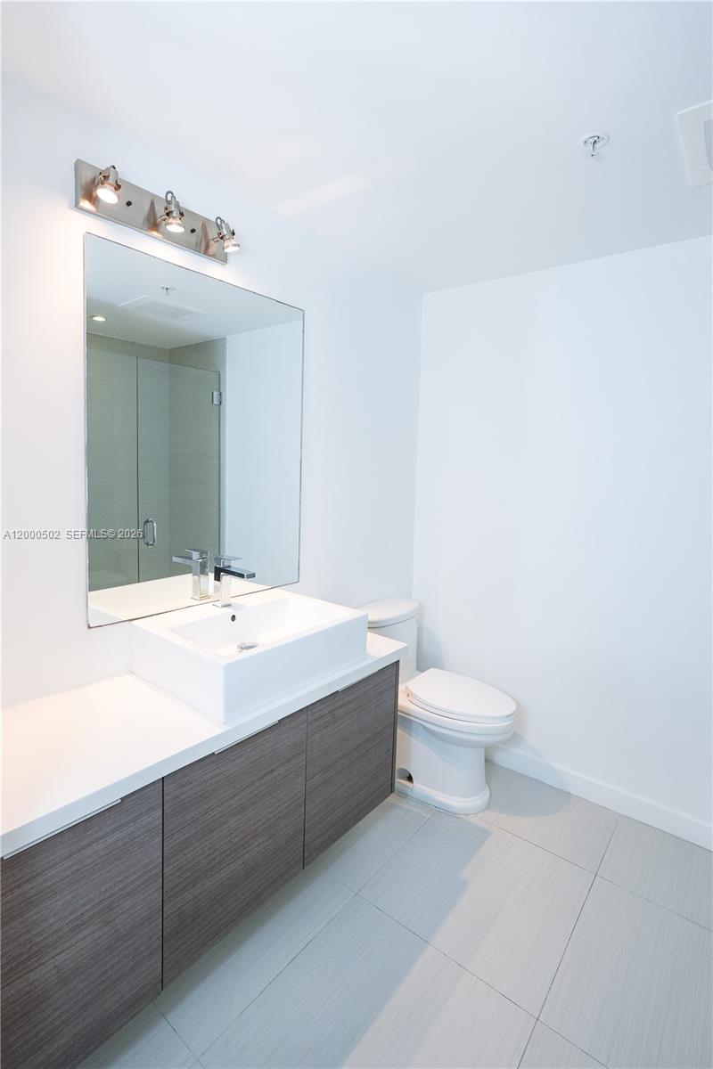1010 Southwest 2nd Avenue, Unit 606 Miami, FL 33130 - Photo 9 of 46 a bathroom with a sink mirror and toilet