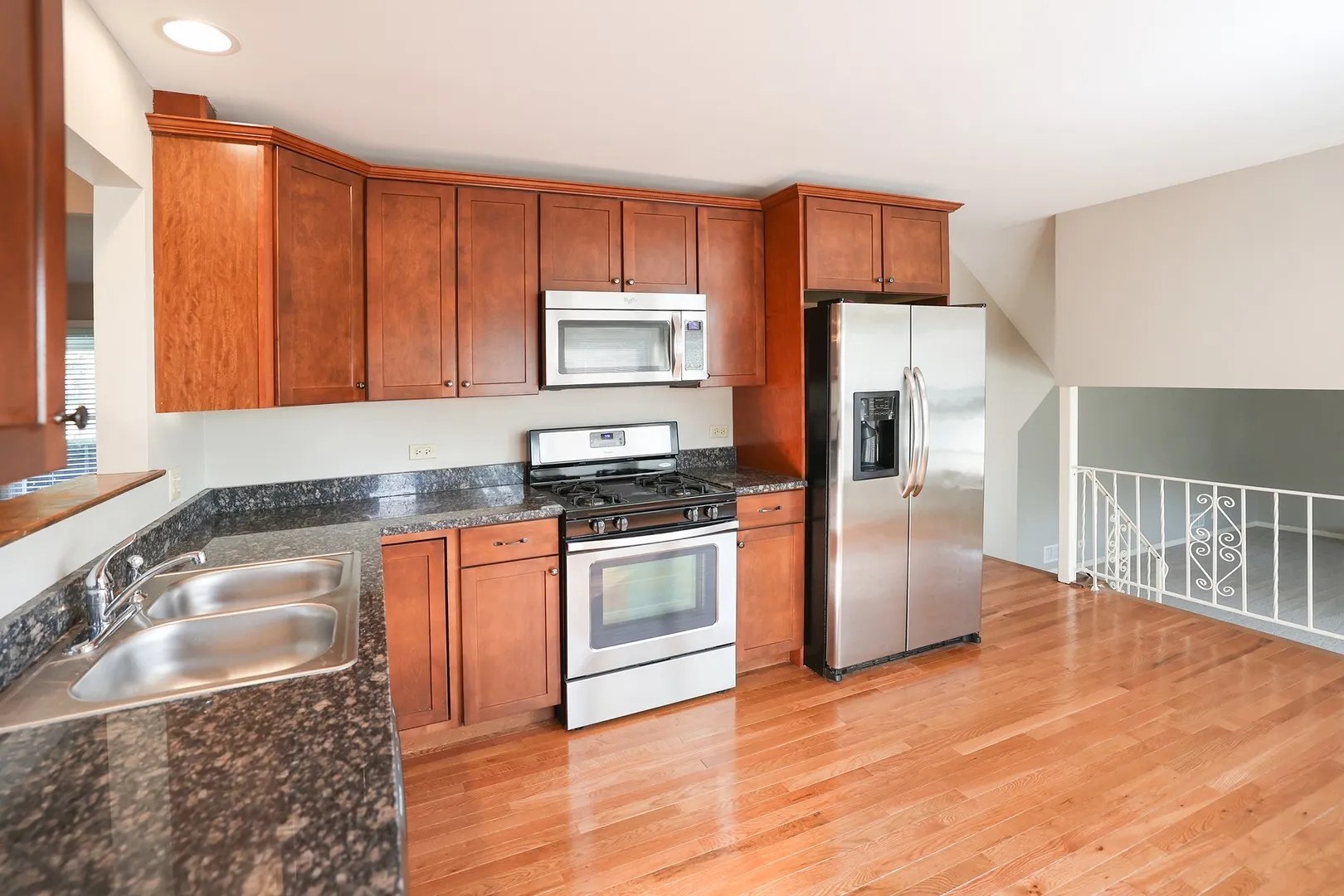 1329 Stonegate Road Naperville, IL 60540 - Photo 18 of 19 a kitchen with granite countertop wooden cabinets a stove a oven and a refrigerator with wooden floor
