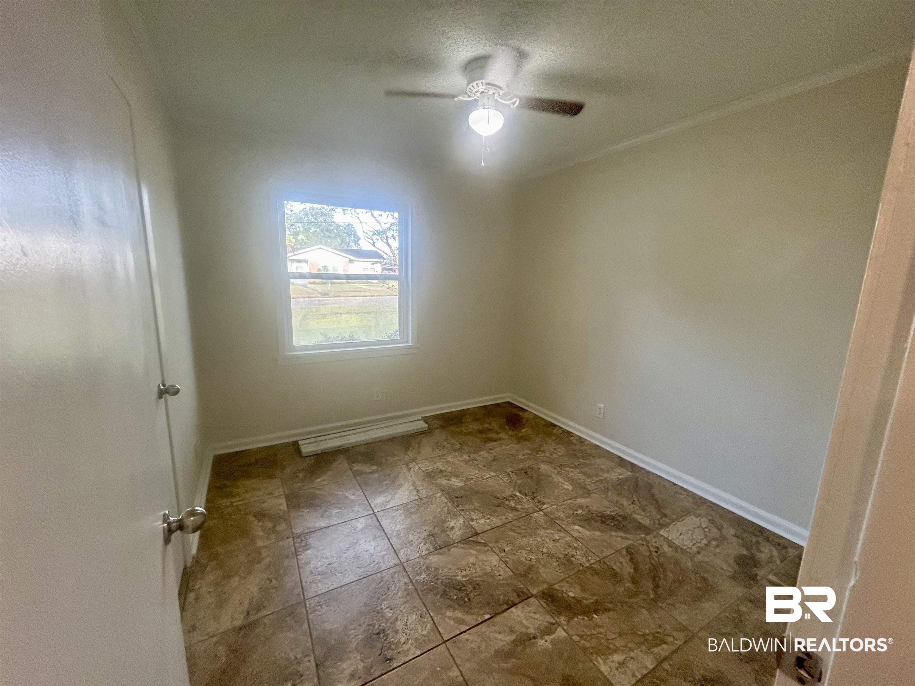 187 Van Hoosen Road Flomaton, AL 36441 - Photo 17 of 29 Unfurnished room with a textured ceiling, ornamental molding, and a ceiling fan