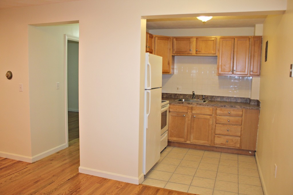 46 Adams Street, Unit A6 Boston, MA 02122 - Photo 8 of 11 a kitchen with white cabinets and white appliances