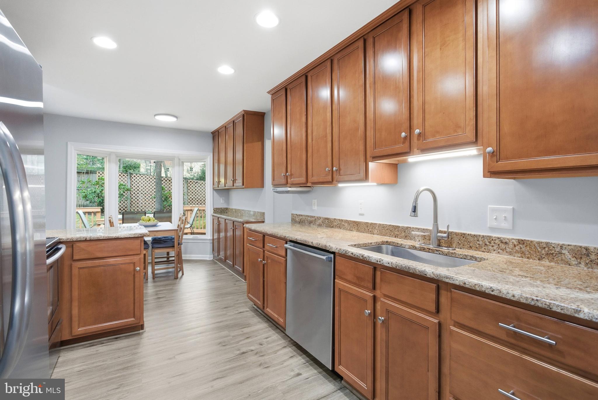 7400 Dorothy Court Springfield, VA 22153 - Photo 6 of 54 a kitchen with stainless steel appliances granite countertop wooden cabinets a sink and dishwasher a oven with wooden floors