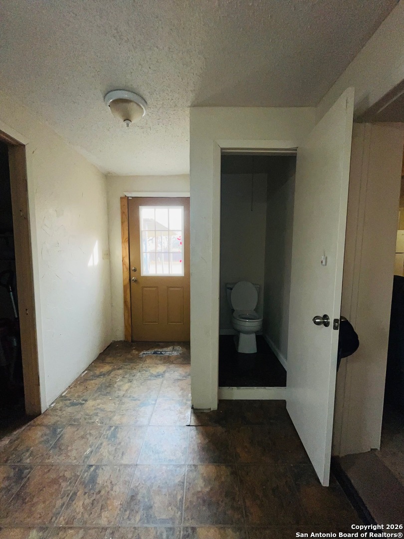 200 West Frio Street Dilley, TX 78017 - Photo 14 of 18 an empty room with an entryway and a window