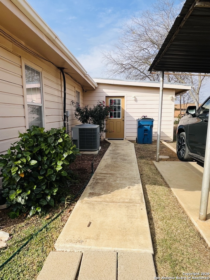 200 West Frio Street Dilley, TX 78017 - Photo 15 of 18 a view of a patio with table and chairs potted plants with wooden floor