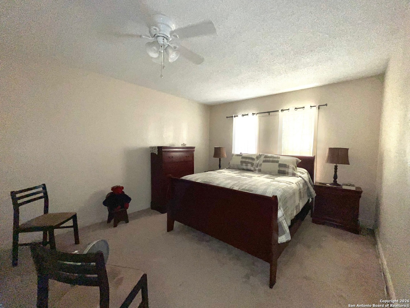 200 West Frio Street Dilley, TX 78017 - Photo 10 of 18 a spacious bedroom with a bed and a chandelier