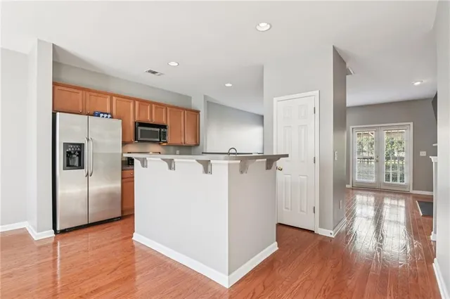 a kitchen with stainless steel appliances granite countertop a refrigerator a stove and a wooden floors