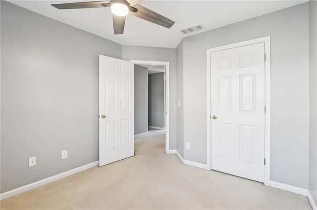 an empty room with chandelier fan