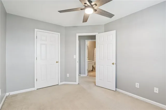 an empty room with a ceiling fan and a fan