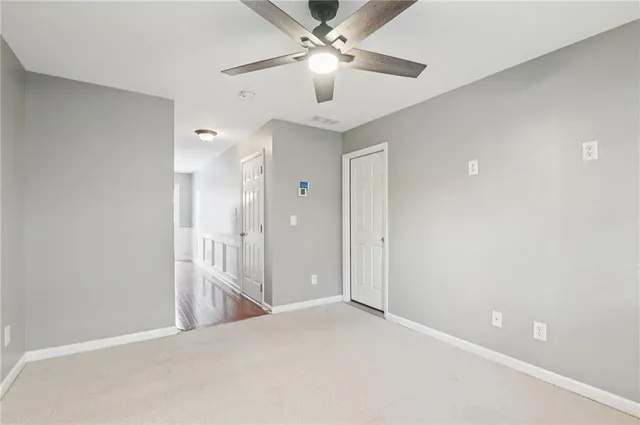 a view of a room with a ceiling fan and entryway