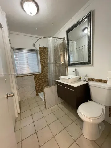 a bathroom with a double vanity sink toilet and mirror