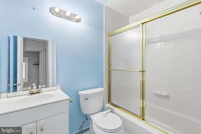 a bathroom with a sink mirror vanity and toilet
